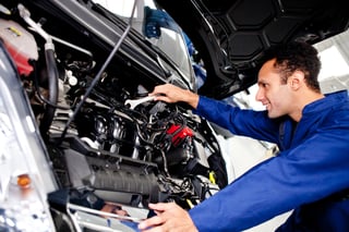 Car mechanic fixing a broken engine at the garage