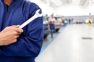 Mechanic holding a wrench at a car garage