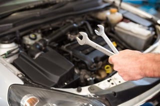 Mechanic holding two types of wrench in the repair garage