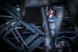 car-mechanic-between-lifts-2023-11-27-05-10-53-utc