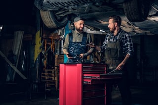 two-mechanics-working-under-the-car-in-a-garage-2023-11-27-05-18-51-utc